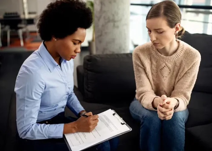 Counselor taking notes while speaking with a client about depression treatment in Katy, Texas