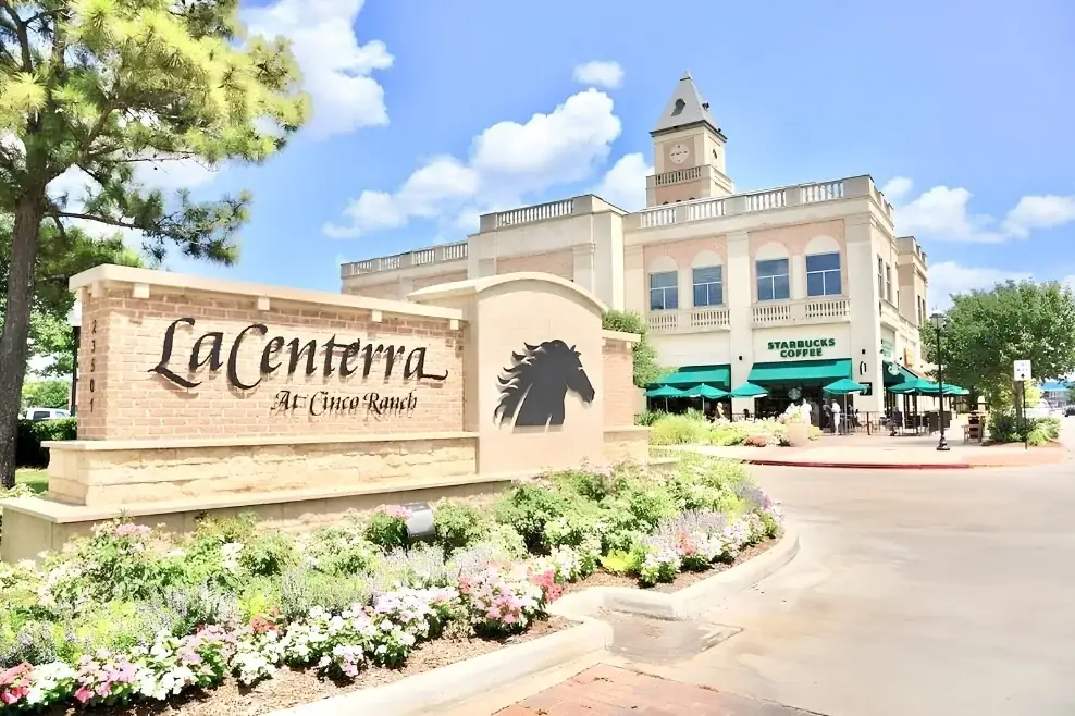 LaCenterra at Cinco Ranch entrance sign with the horse logo and landscaped flower beds in Katy, Texas