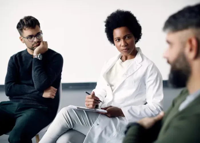 Provider taking notes during a group therapy session for psychotic disorder treatment in Katy, Texas