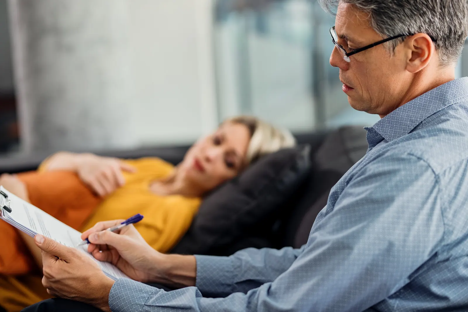 Psychiatrist taking notes during a patient evaluation and consultation